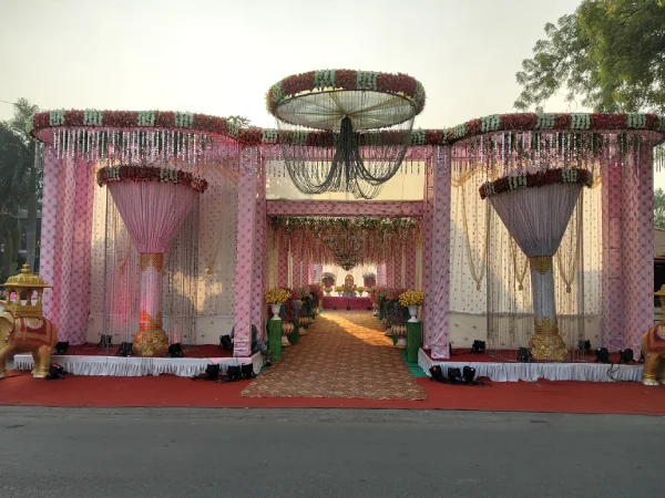 Reception: Symmetrical pink-white drapes; central chandelier; floral swags